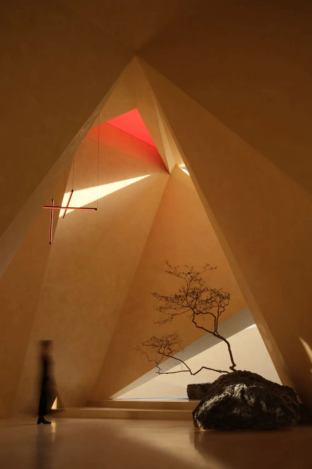 Bir iç mekanda ışık ve gölgenin yarattığı dramatik etkiyi gösteren modern bir sanat galerisi örneği.