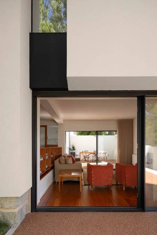 Geniş pencerelerle bahçeye açılan yaşam alanında Modern Mimari uygulaması.